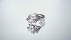 This is a video of a twin cultured pearl ring with natural diamond accents in white gold shown turning slowly on a mirrored background.