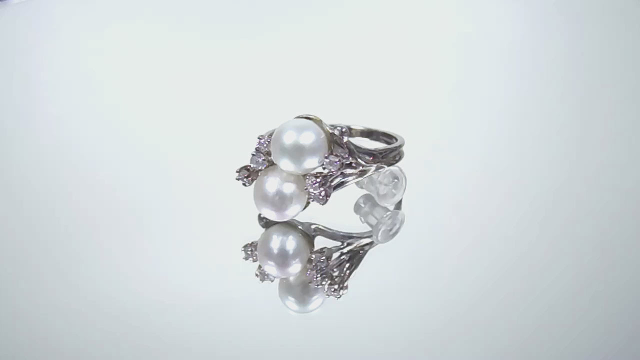 This is a video of a twin cultured pearl ring with natural diamond accents in white gold shown turning slowly on a mirrored background.