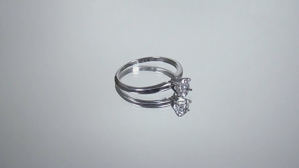 This is a video of a white gold natural oval shape diamond solitaire turning on a mirrored background.