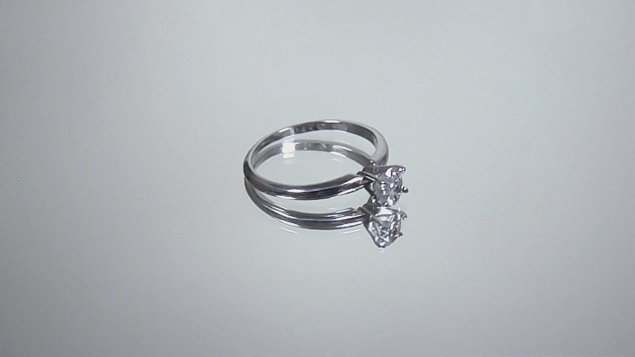 This is a video of a white gold natural oval shape diamond solitaire turning on a mirrored background.