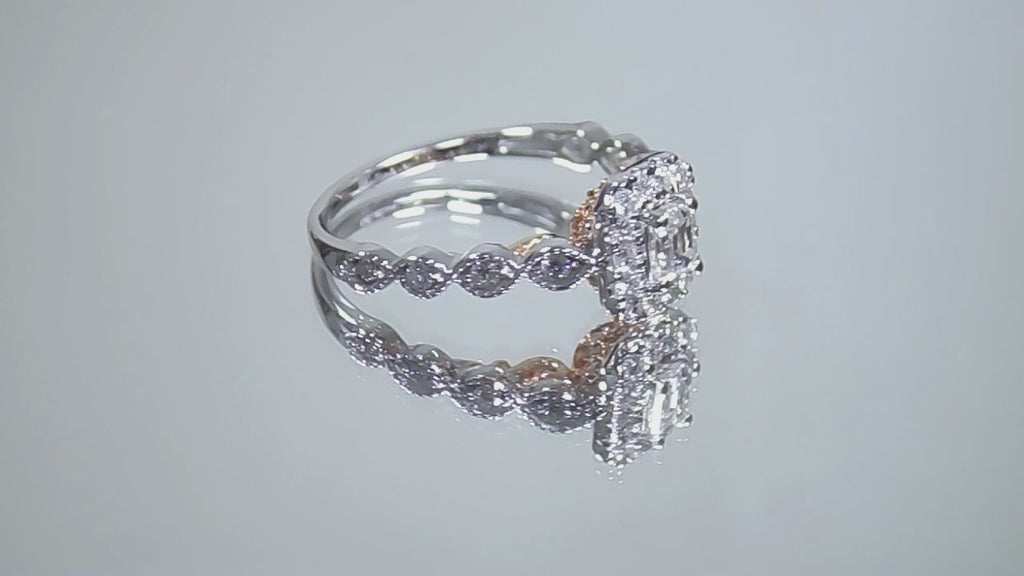 This is a video of a .75ct natural emerald cut halo style ring with infinity style band in white gold with rose gold accents on the sides turning slowly on a mirrored background.
