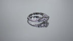 This is a bezel set marquise shape diamond set sideways in a white gold filigree ring shown turning slowly on mirrored background.