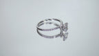 This a video of a 1ct total weight natural oval shape diamond set on a straight line diamond band in white gold shown turning slowly around on a mirrored white background.