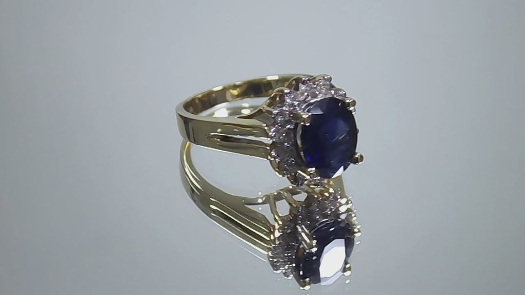 This is a women's estate LeVian ring with a 3.50ct total weight sapphire and diamonds set in 14K yellow gold on a mirrored surface rotating in a video.