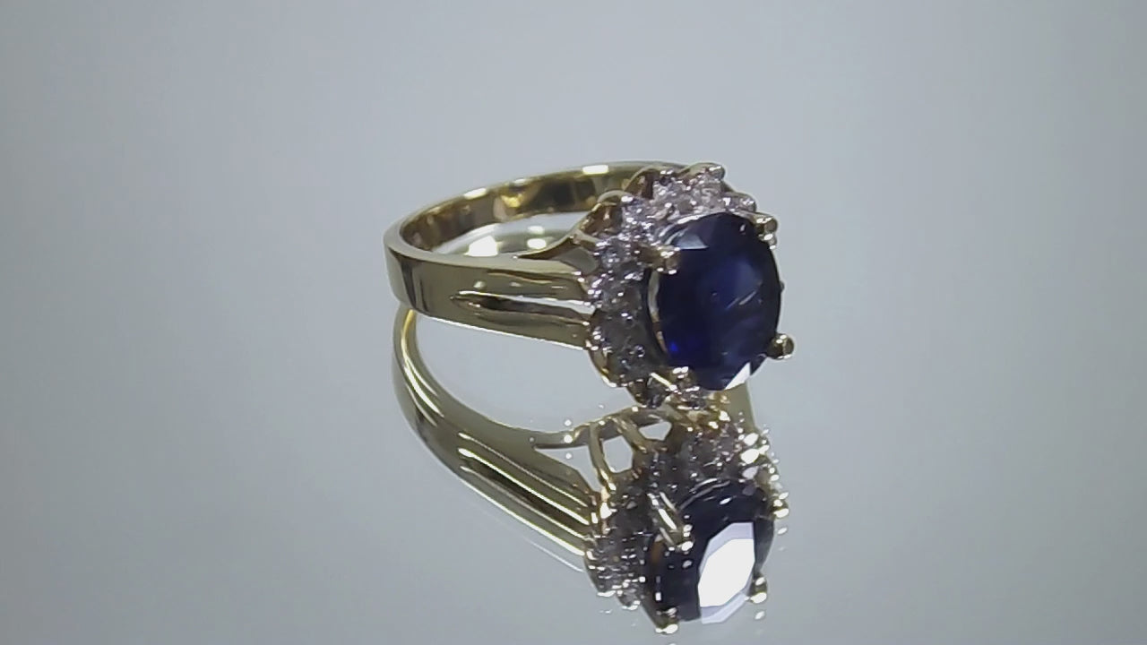 This is a women's estate LeVian ring with a 3.50ct total weight sapphire and diamonds set in 14K yellow gold on a mirrored surface rotating in a video.