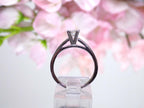 This is side view of a natural diamond princess cut solitaire engagement ring in white gold with floral background. 