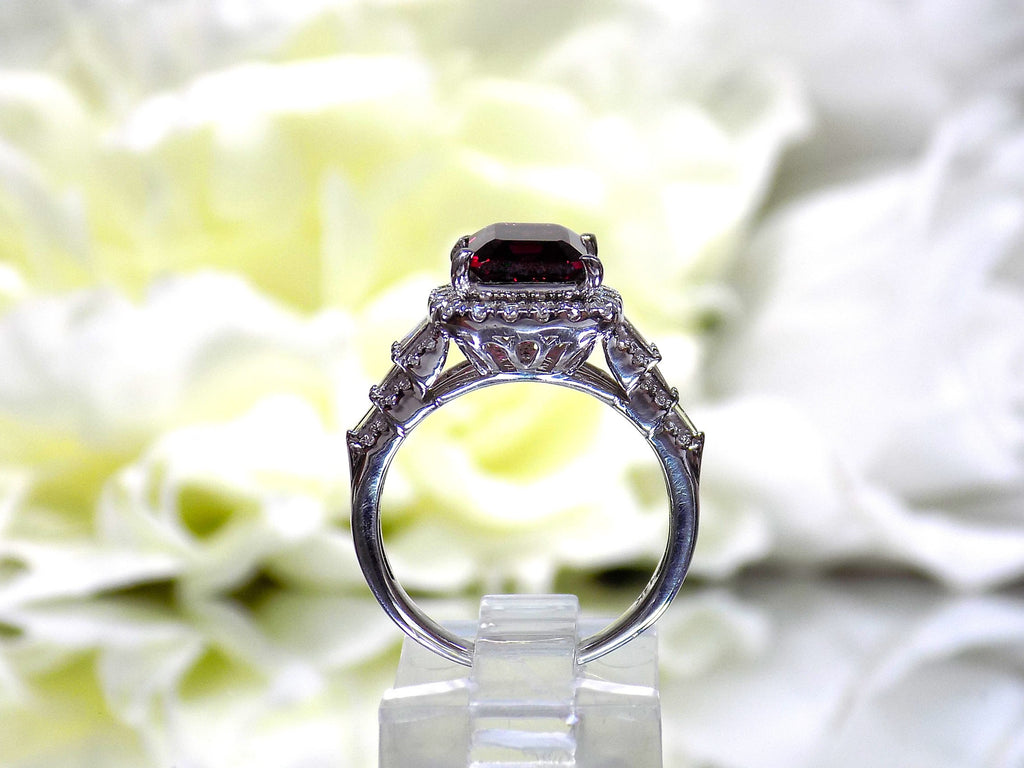 This is a side view of a woman's 3.95ct total weight rhodolite garnet and diamond ring in white gold with yellow white background.