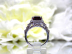 This is a side view of a woman's 3.95ct total weight rhodolite garnet and diamond ring in white gold with yellow white background.