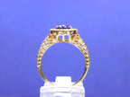 This is a women's natural 1.47ct oval sapphire ring with .33ct total weight natural diamond accents in 14K yellow gold on a blue background from a side view.