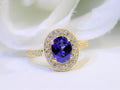 This is a women's natural 1.47ct oval sapphire ring with .33ct total weight natural diamond accents in 14K yellow gold on a white background.