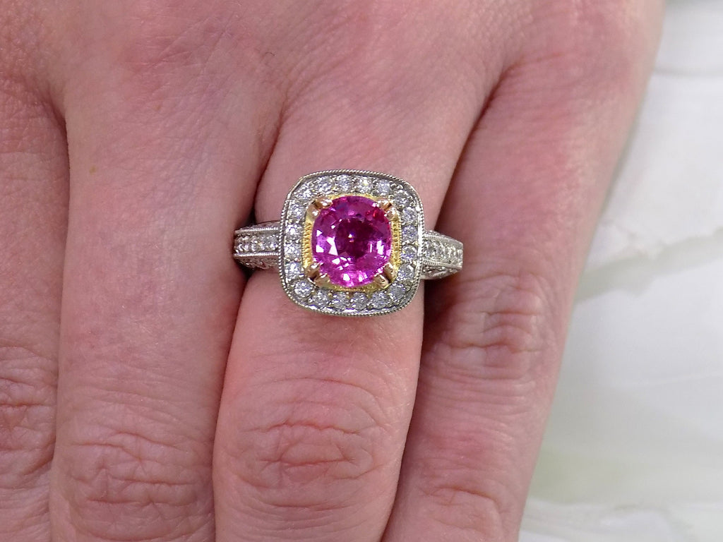 This is a women's ring with a natural 2.21ct pink sapphire in the center with a total weight of .86ct natural round diamond accents set in 18K white and yellow gold on a women's finger with a white background.