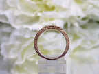 This is a side view of the matching band to a 2pc 1.25ct total weight natural diamond princess cut wedding in rose gold with yellow flowery backgound.