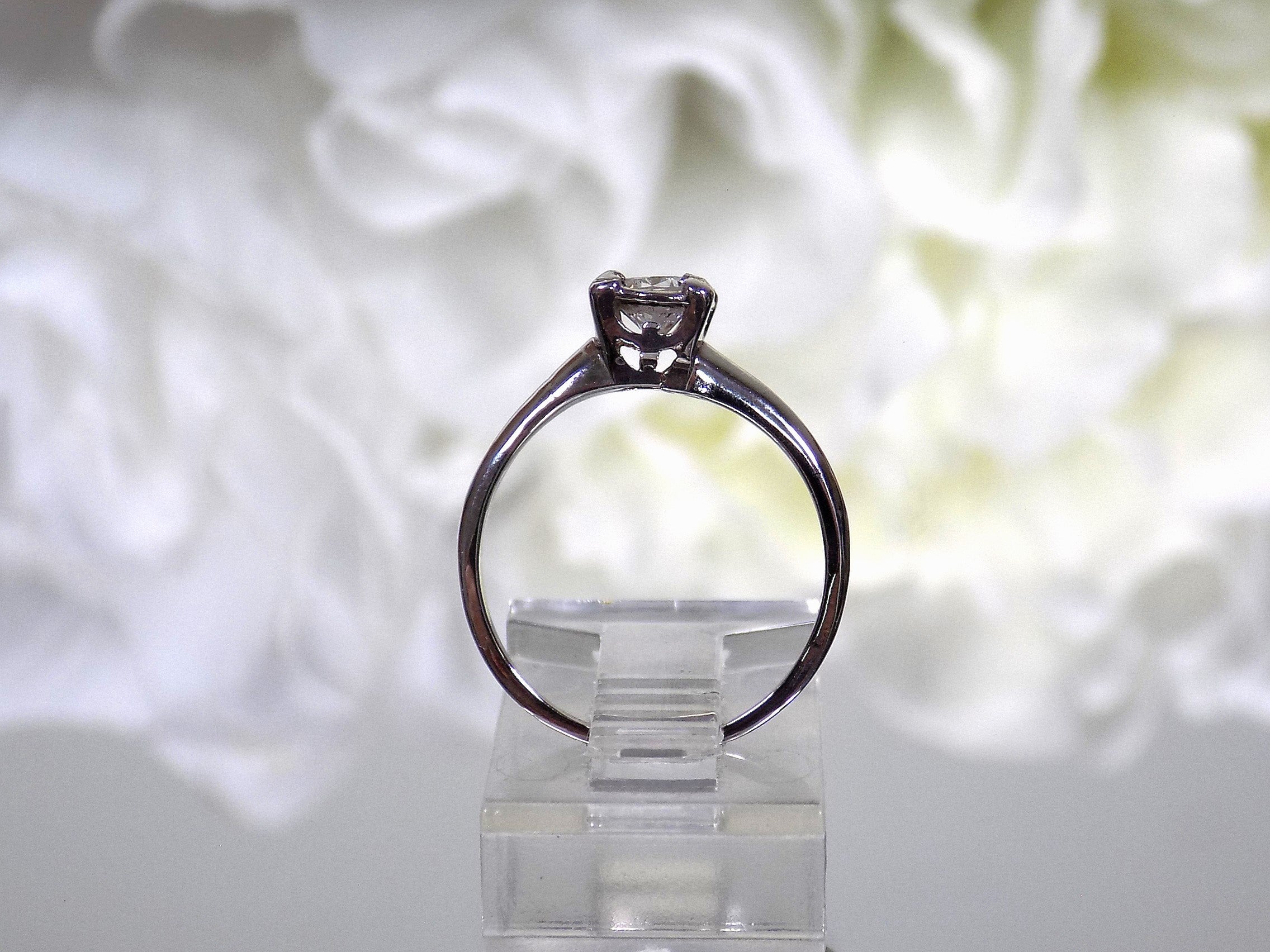 This is an estate .45ct round diamond solitaire ring in white gold shown from the side with a white background.