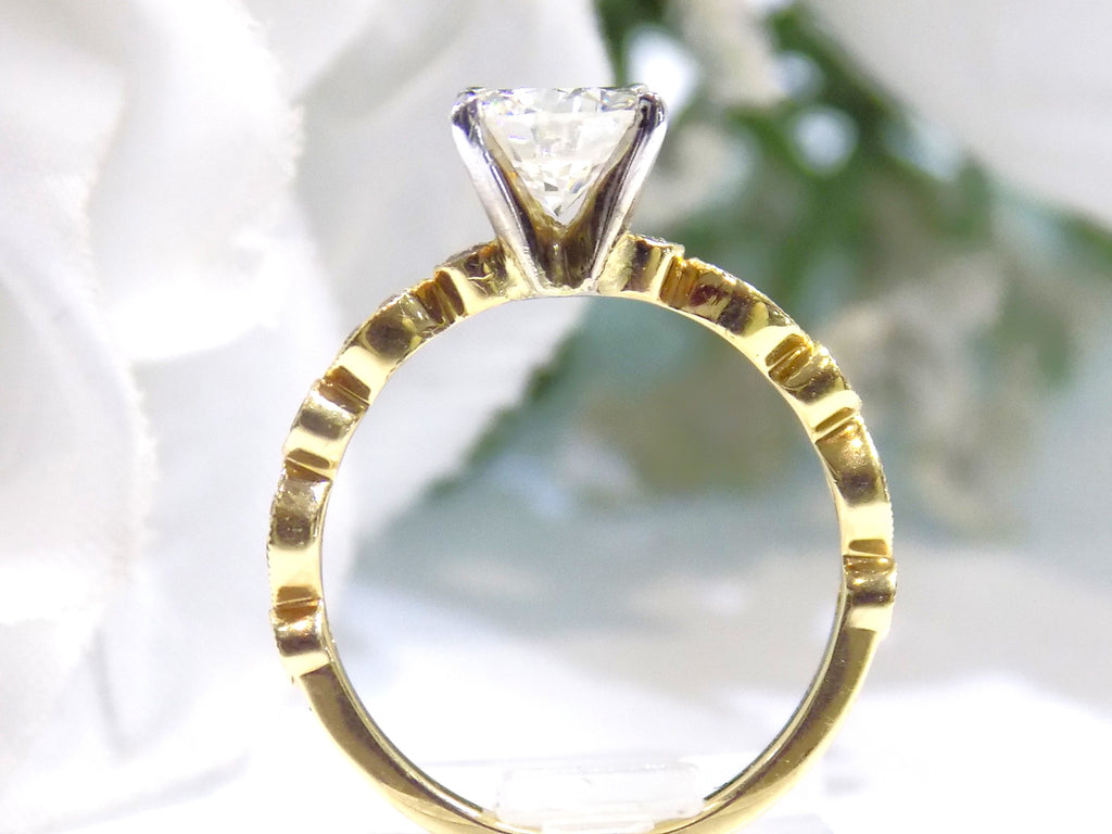 This is a side view of a women's natural round brilliant diamond ring with a 1.10ct round center and .22ct in diamond accents set in yellow gold shown with a white background.