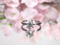 The is a natural .60ct round brilliant diamond solitaire engagement ring in white gold with flowery background.