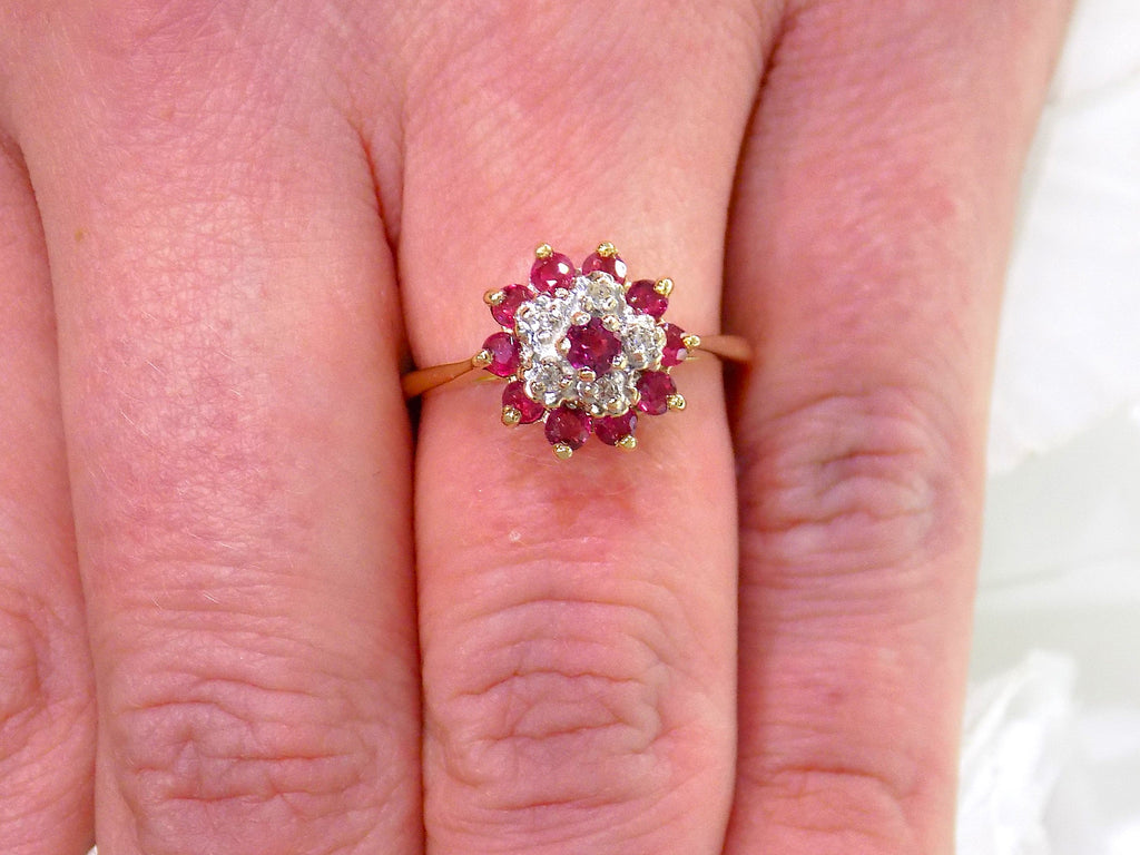 The is a genuine ruby and diamond ring in  yellow gold from our estate collection in like new condition shown on a woman's finger.