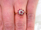 The is a genuine ruby and diamond ring in  yellow gold from our estate collection in like new condition shown on a woman's finger.