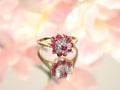 The is a genuine ruby and diamond ring in  yellow gold from our estate collection in like new condition with pink  flowery background.