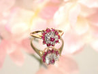 The is a genuine ruby and diamond ring in  yellow gold from our estate collection in like new condition with pink  flowery background.