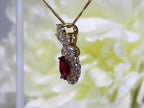 This is a side view of a woman's 3.06ct total weight oval ruby plus natural diamond pendant is in yellow gold with yellow/white flowery background.