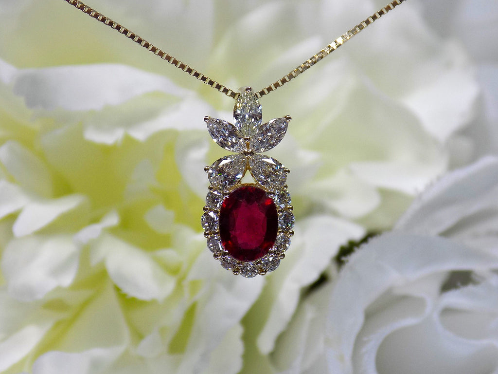 This is a woman's 3.06ct total weight oval ruby plus natural diamond pendant is in yellow gold with yellow/white flowery background.