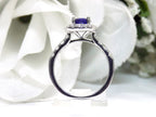 This is a side view of women's halo style 2ct total weight round sapphire and diamond ring in white gold with a white blue background.