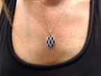 This is a women's 2.35ct total weight natural sapphire and diamond pendant in white gold shown on a woman's neck.