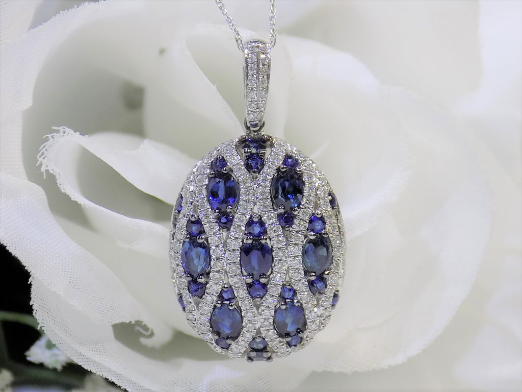 This is a women's 2.35ct total weight natural sapphire and diamond pendant in white gold with a white rose background.
