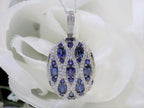 This is a women's 2.35ct total weight natural sapphire and diamond pendant in white gold with a white rose background.