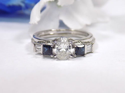 This is a white gold sapphire and diamond ring guard or wrap shown with an oval solitaire placed in the center.