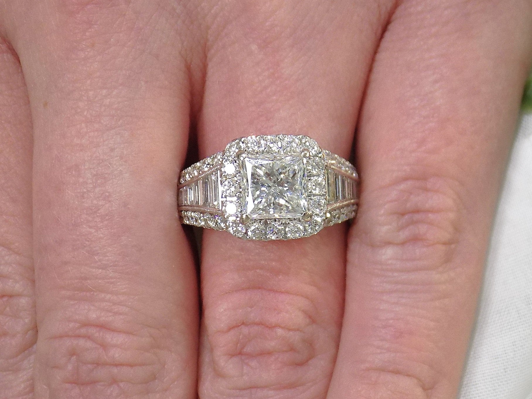 This is 3.68ct total weight natural diamond ring with a 2.05ct natural princess cut set in a legendary designer Simon G white gold mounting shown on a woman's finger.