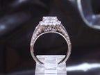 This is a side view of a 3.68ct total weight natural diamond ring with a 2.05ct natural princess cut set in a legendary designer Simon G white gold mounting with a black background.
