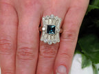 This is a women's 1.78ct total weight natural indicolite tourmaline and diamond Victorian style ring in white gold shown on a woman's finger.