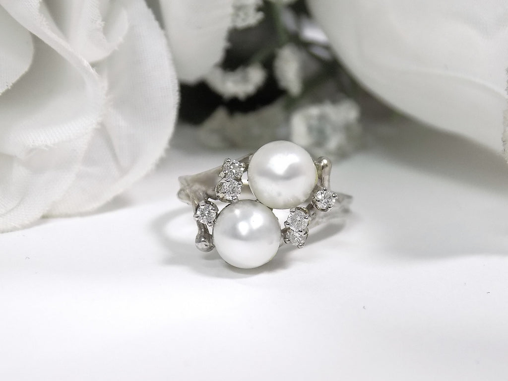 This is a twin cultured pearl ring with natural diamond accents in white gold shown on a white background.