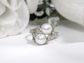 This is a twin cultured pearl ring with natural diamond accents in white gold shown on a white background.