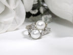 This is a twin cultured pearl ring with natural diamond accents in white gold shown on a white background.