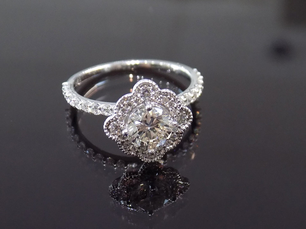 This is a 1.25ct total weight natural diamond ring with a .84ct natural round brilliant diamond in the center in white gold shown on a mirrored black background.