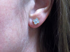 This is a pair of earrings in Van Cleef style with natural diamonds win 2 tone white and yellow gold in a womans ear.