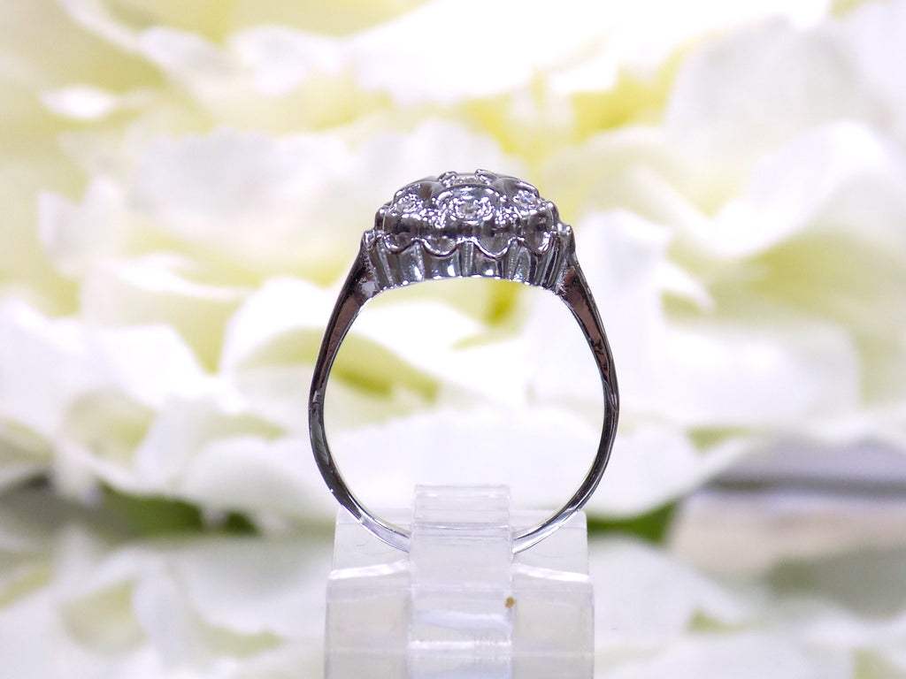 This is a side view of a 7 stone .10ct Total Weight Natural Diamond Vintage Ring in 14K White Gold.