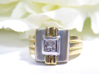 This is a woman's vintage art-deco ring that is two-tone with a brushed 18K yellow and white gold finish with .20ct total diamond weight with a floral background.