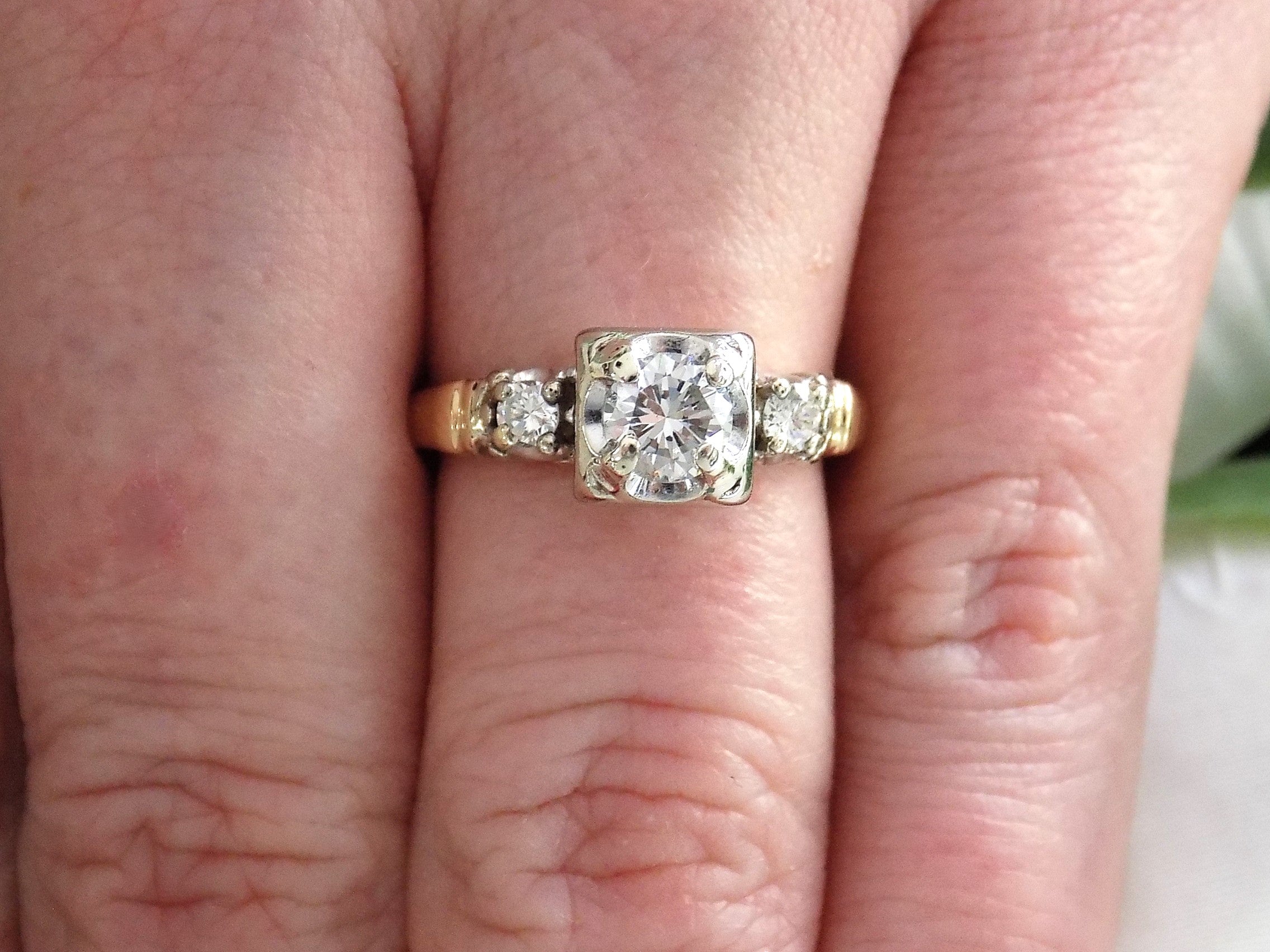 This is a Vintage .59ct ladies natural diamond wedding ring in yellow gold shown on a woman's finger.