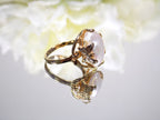 This is a genuine freshwater pearl ring in yellow gold on white mirrored background. 