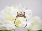 This is a side view of a genuine freshwater pearl ring in yellow gold shown on white background.