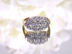 This women's ring is called "princess" style ring usually passed down from mother to daughter throughout the generations.  It a yellow gold ring with diamonds mounted in white gold in the top and has a white flowery background.