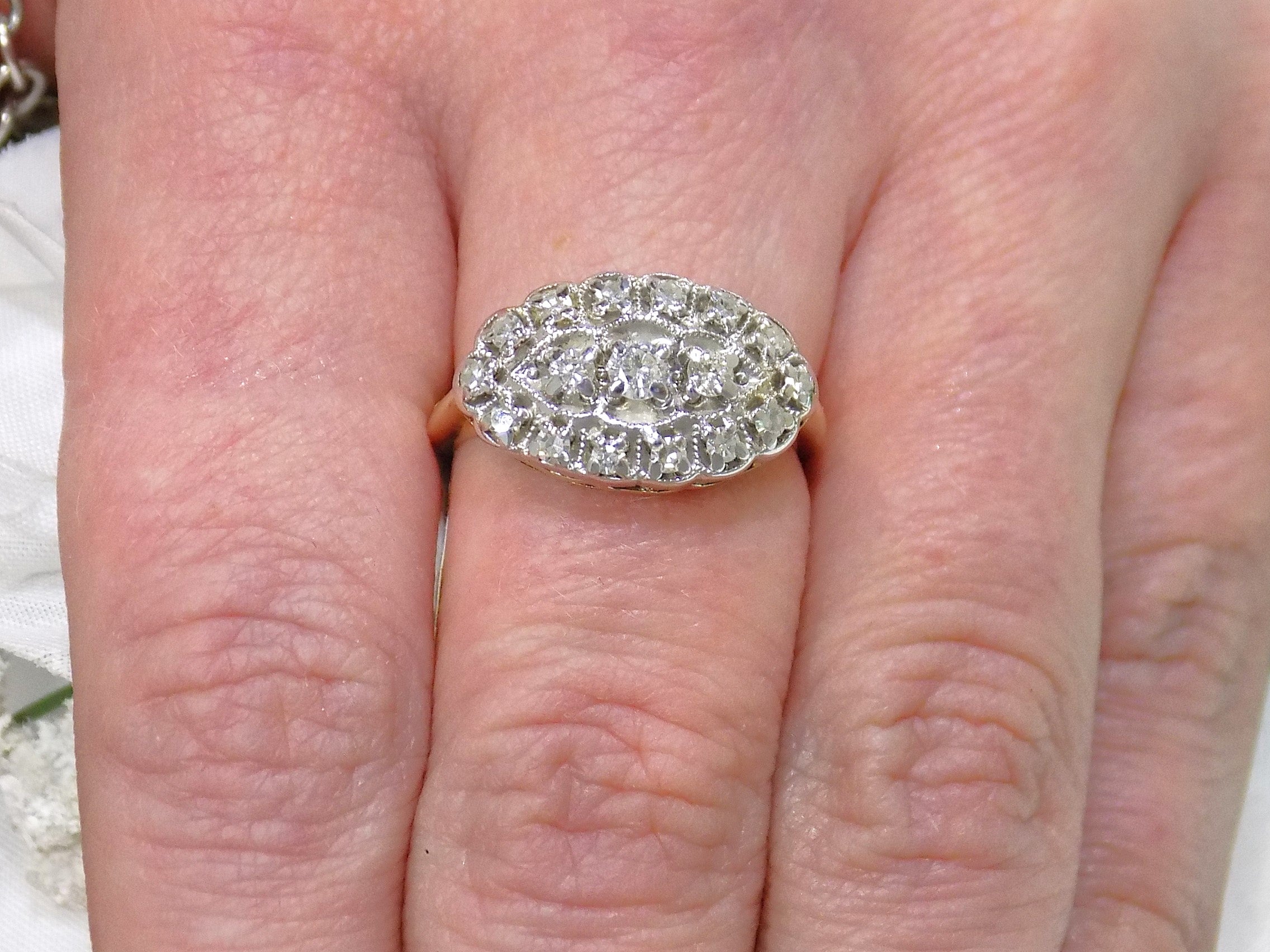 This women's ring is called "princess" style ring usually passed down from mother to daughter throughout the generations.  It a yellow gold ring with diamonds mounted in white gold in the top and shown on a ladies' finger.