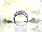 This is a vintage variation of the princess style women's ring with 3 primary diamond in the center with a total weight of .25ct in 14K white gold with a white background in a side view.