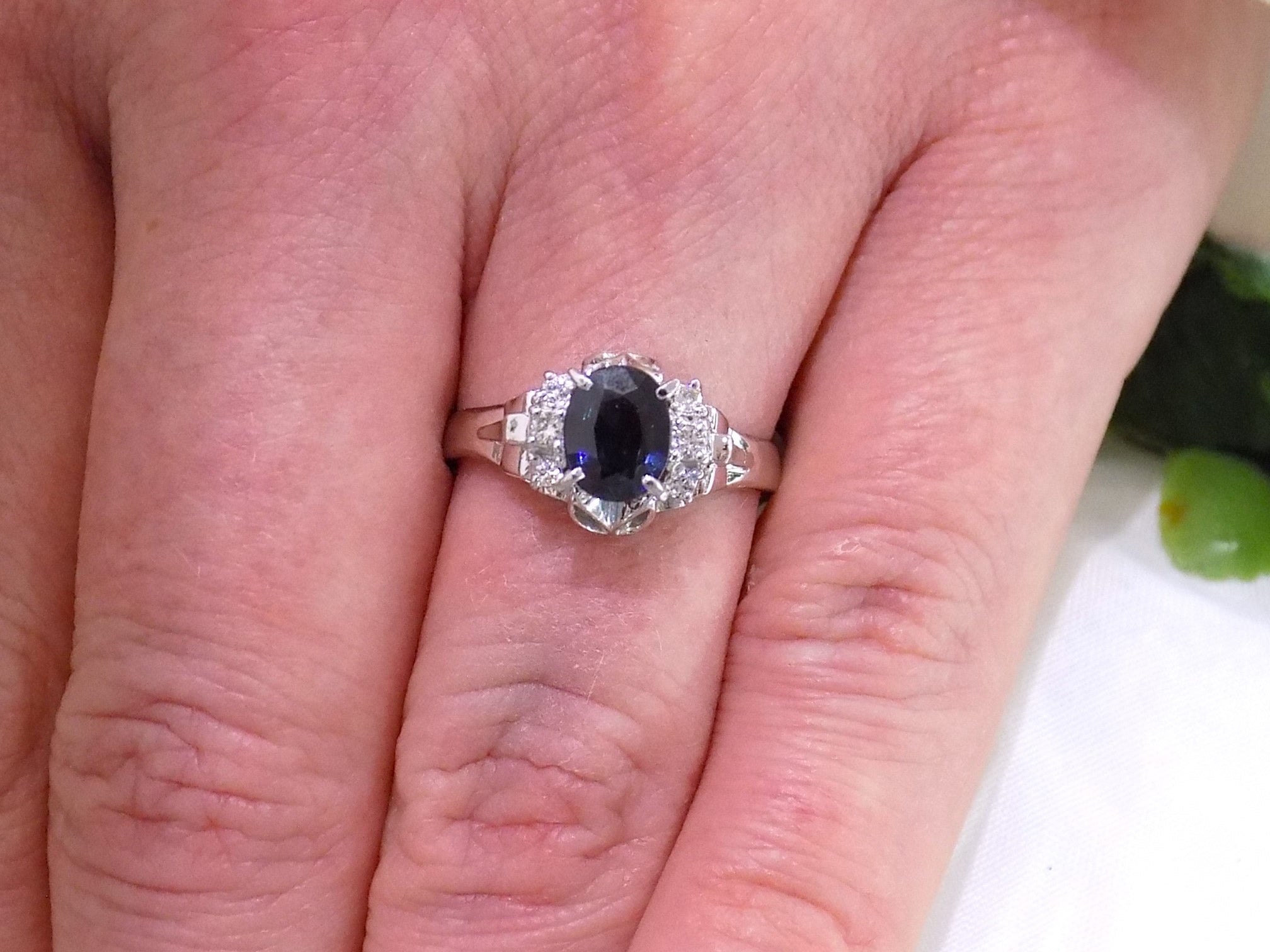 This is women's a vintage pre-world war II genuine oval shape sapphire and natural diamond ring 1.36ct total weight in platinum restored to showcase condition shown on a woman's finger