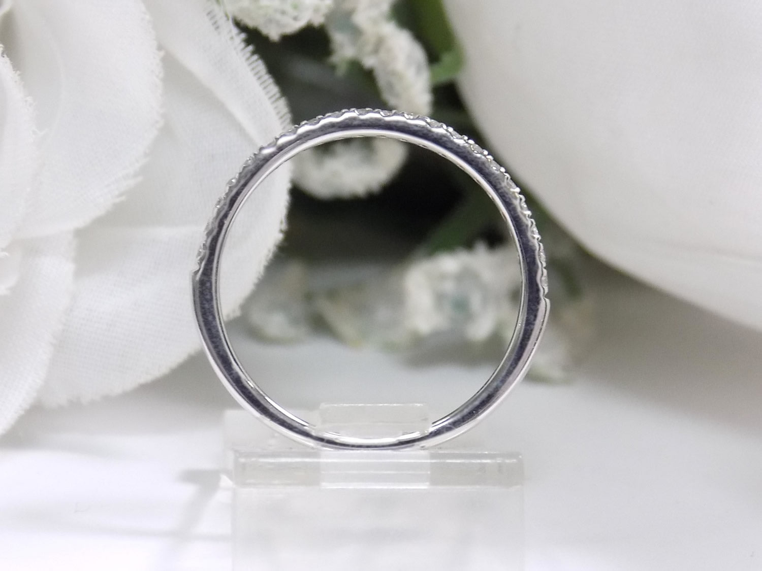This is a side view of the matching band to the halo style women's 2-piece wedding set including the engagement ring and matching band with princess cut center weighing .88ct total in white gold with rose accents shown with white background.