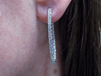 2.00ct total weight natural diamond in and out style oval hoops in 14K white gold in a ladies ear.
