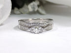 This is a two piece diamond wedding set with the ring and matching band in white gold with white background. 